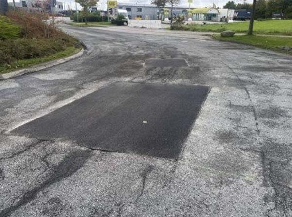 Arbeiter sanieren zum Teil mit schwerem Gerät die Straßenbeläge im Stubbendorfer Gewerbegebiet.